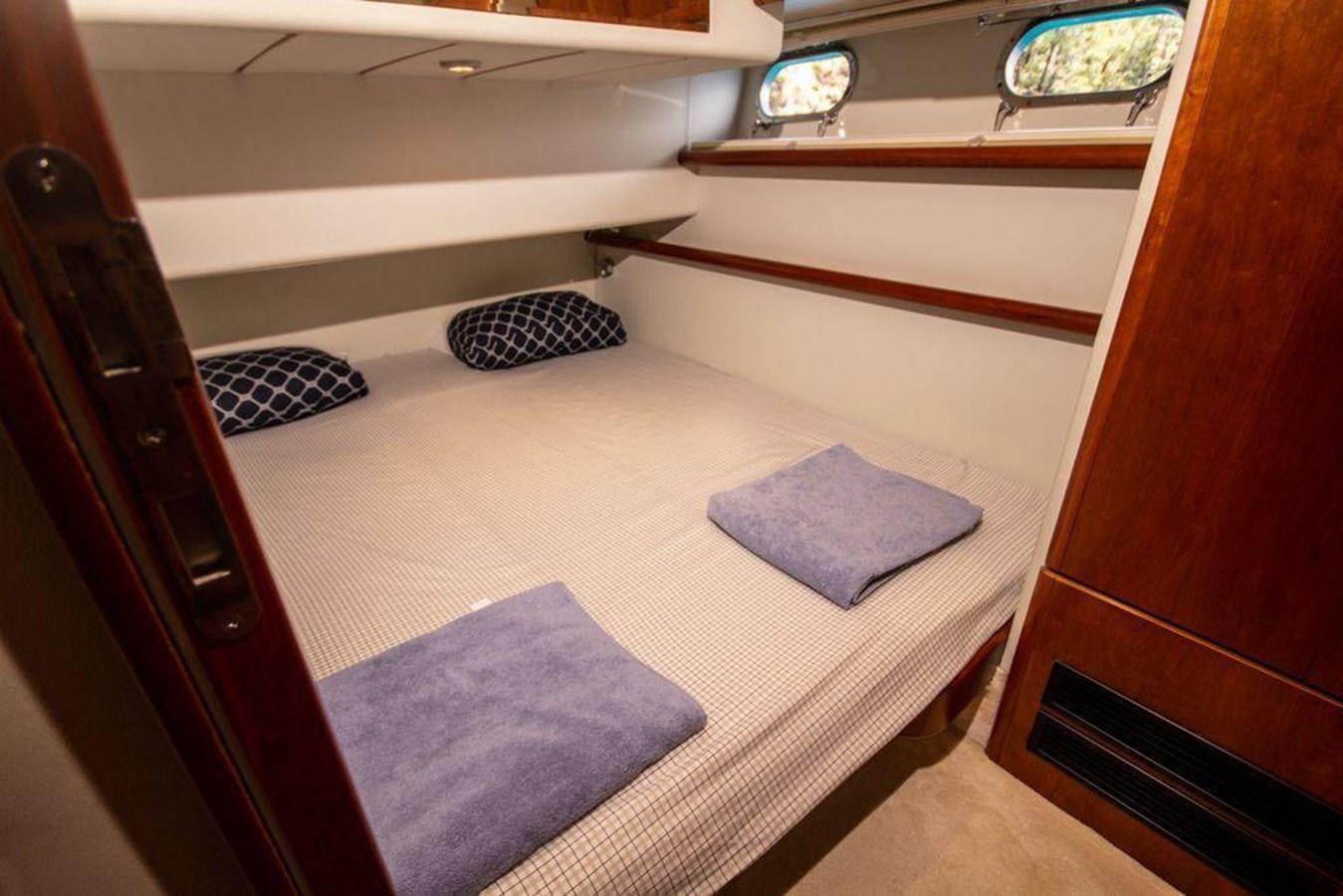 a bed with a blue pillow aboard FERRETTI 760 Yacht for Sale