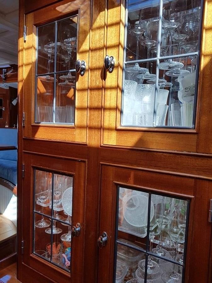 a wooden cabinet with glass doors aboard TIOGA OF HAMBURG Yacht for Sale