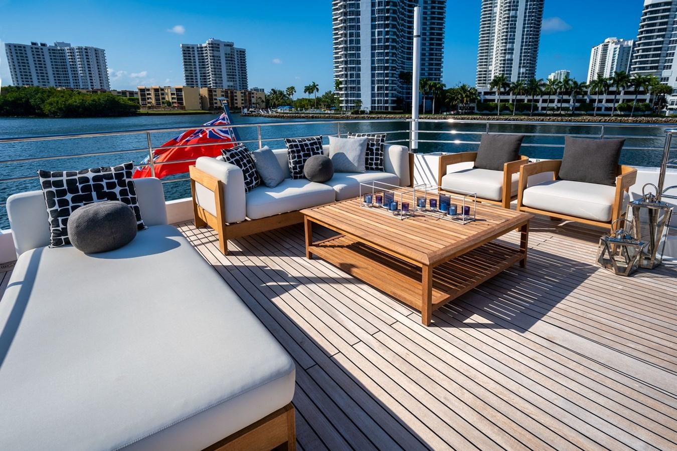 a deck with a table and chairs aboard SANTOSH Yacht for Sale