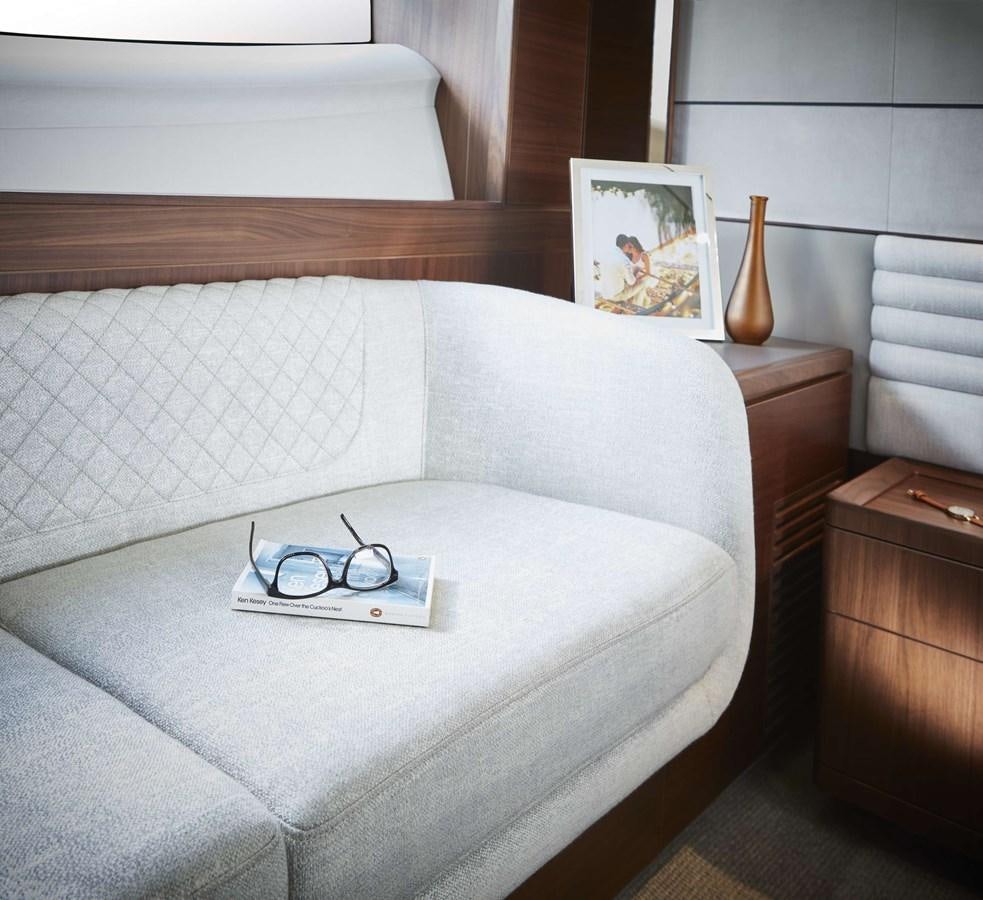 a bed with a white sheet and a picture on the wall aboard SHINE Yacht for Sale