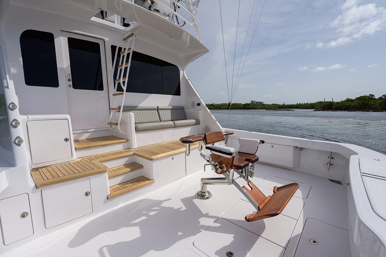 a boat with a wood deck and a wood deck with a view of the water and trees aboard 68 CONVERTIBLE Yacht for Sale
