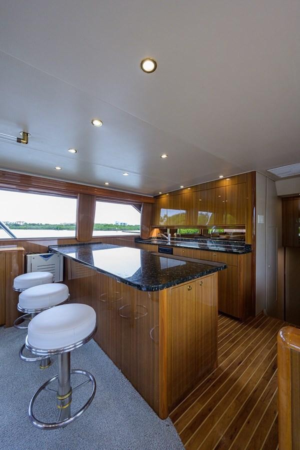 a kitchen with a bar and stools aboard 68 CONVERTIBLE Yacht for Sale