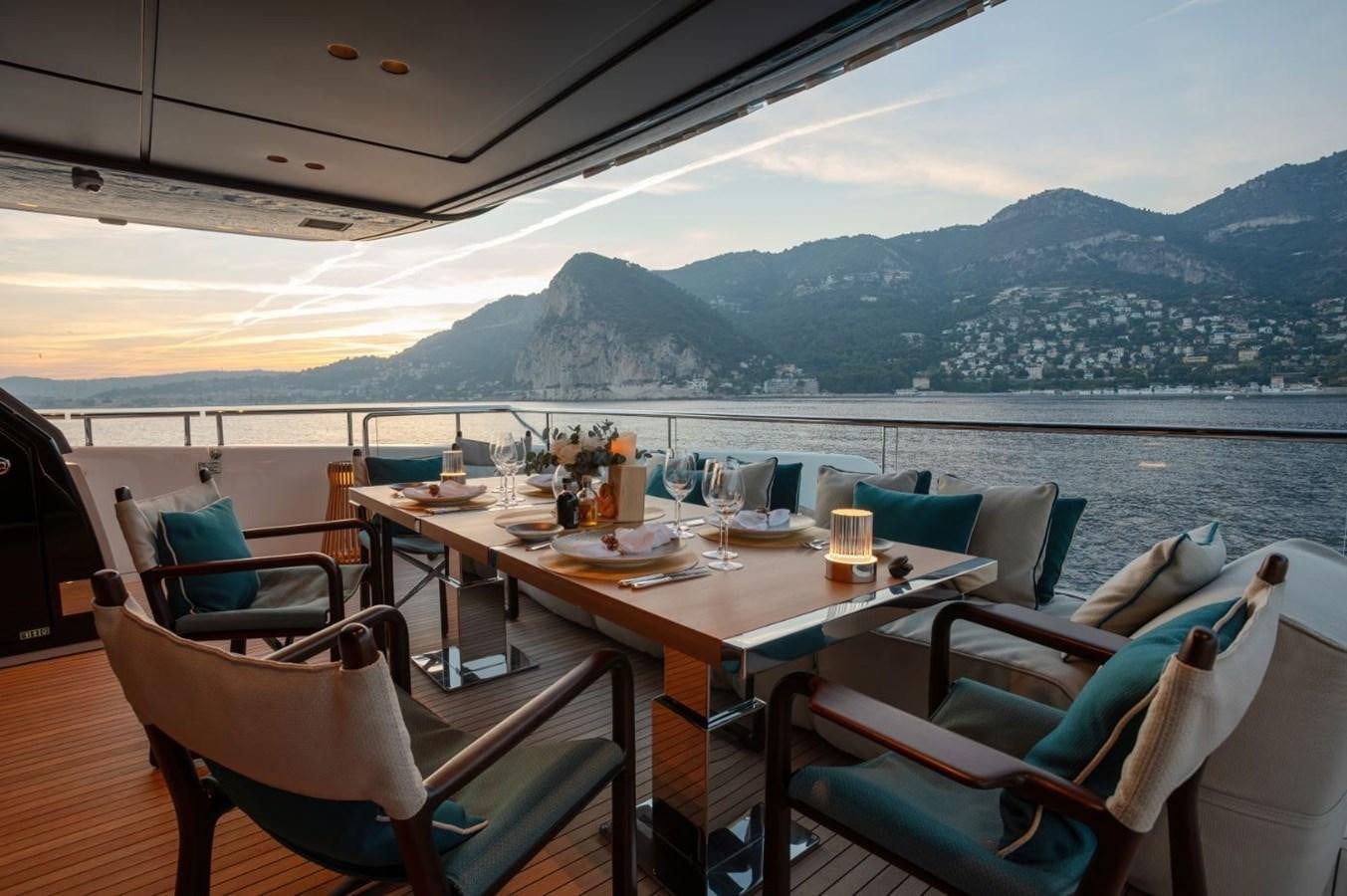 a table set for a meal on a deck overlooking a lake aboard STRADIVARIUS Yacht for Sale