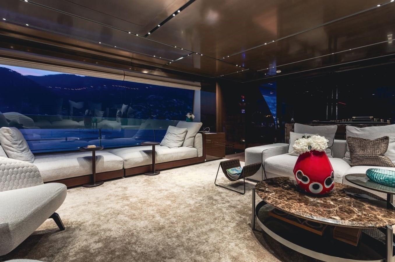 a living room with a large blue couch and a red toy car aboard STRADIVARIUS Yacht for Sale
