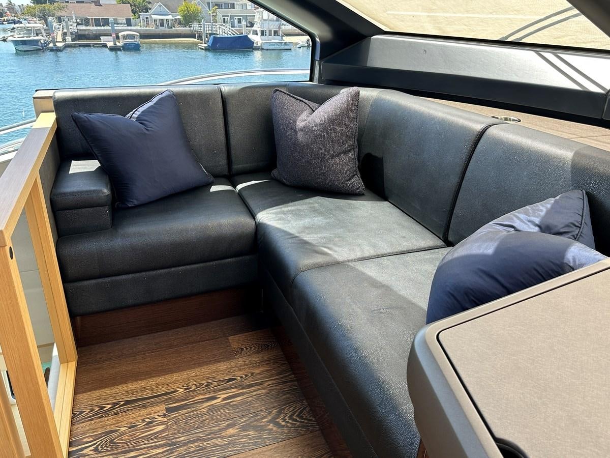 a couch with a table and chairs by a body of water aboard K NUK Yacht for Sale