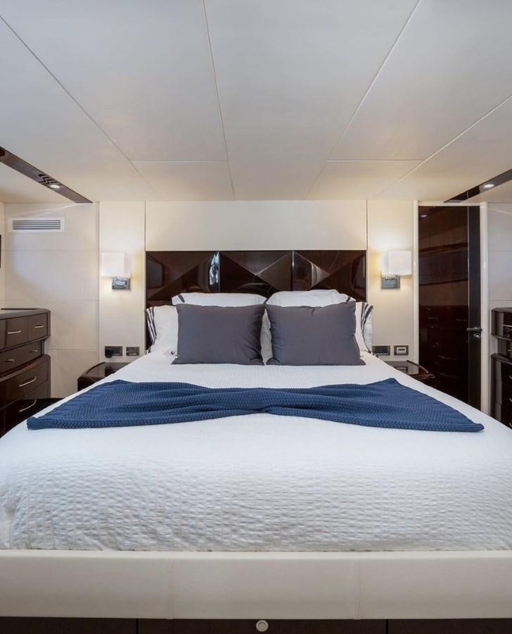 a bed with blue sheets aboard XCELL Yacht for Sale