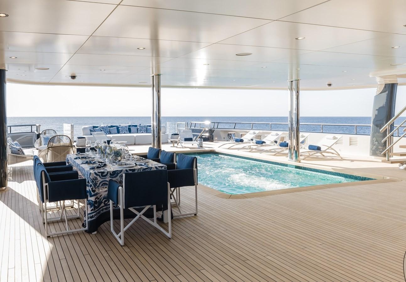 a pool with a deck and chairs aboard HERE COMES THE SUN Yacht for Sale