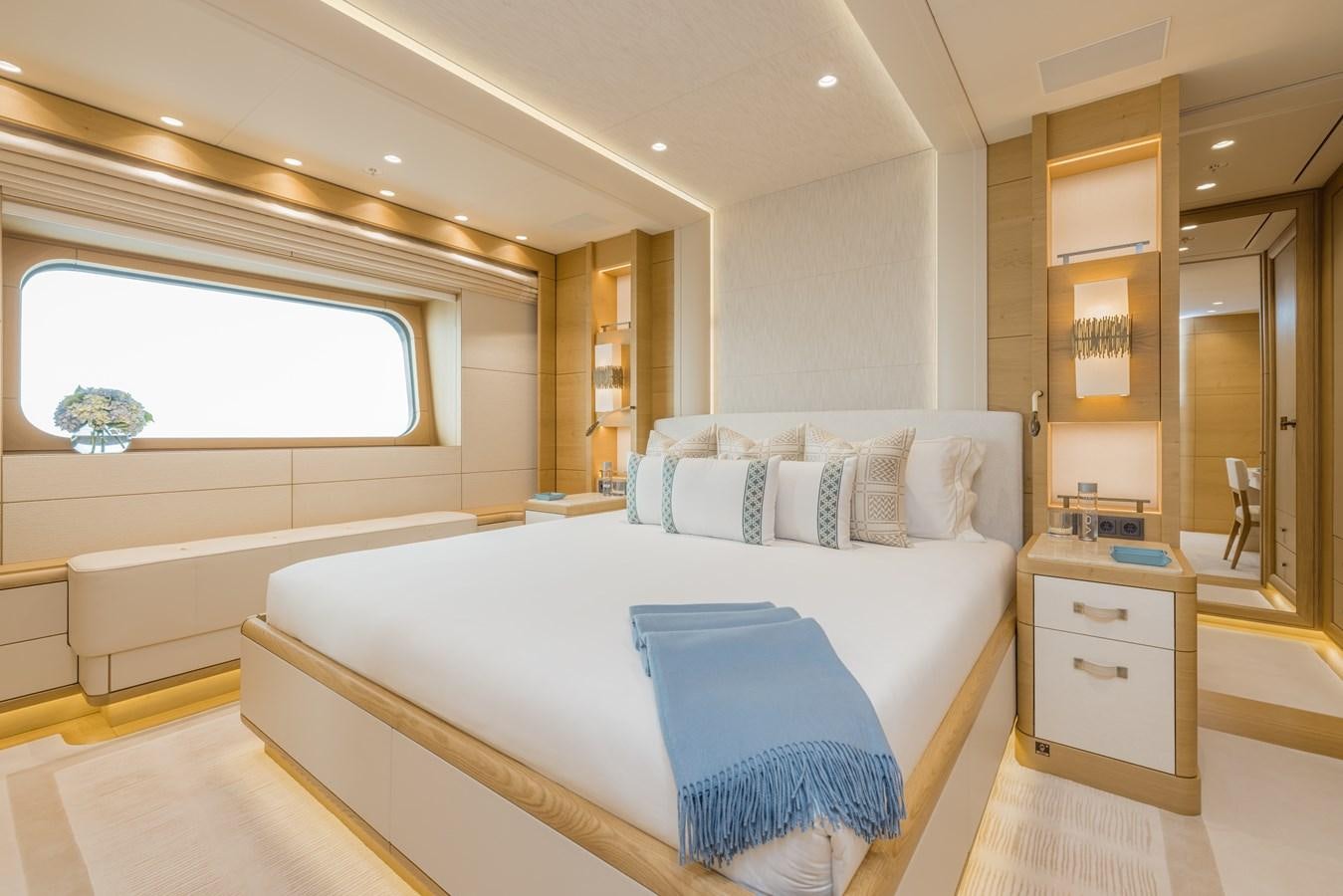 a room with a bed and a window aboard HERE COMES THE SUN Yacht for Sale