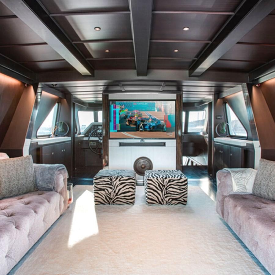a living room with a large screen aboard RA Yacht for Sale