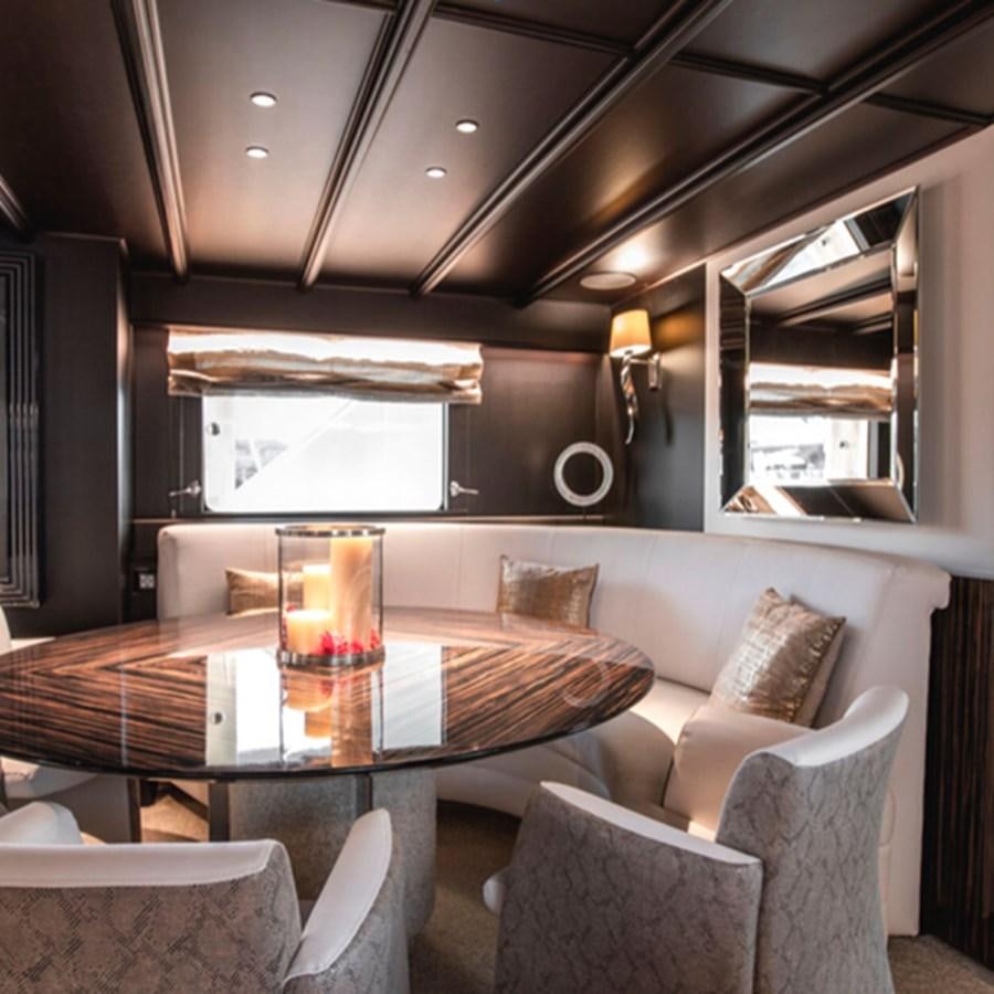 a table with chairs and a glass of beer on it aboard RA Yacht for Sale