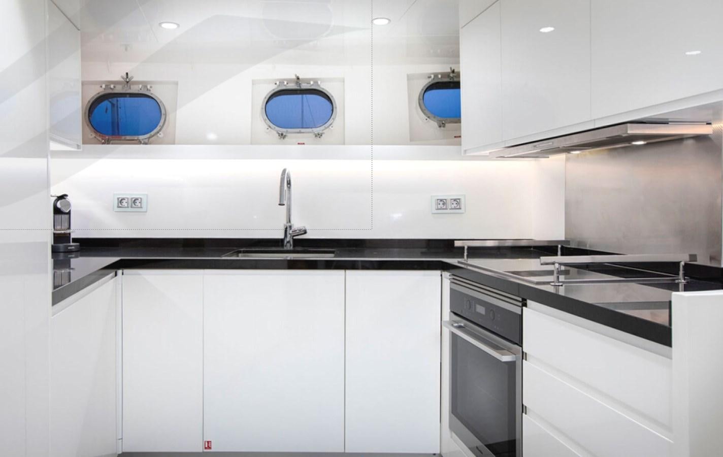 a kitchen with white cabinets aboard RA Yacht for Sale