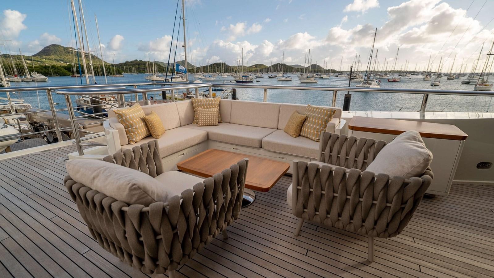 a deck with couches and chairs on it aboard AMIKA Yacht for Sale