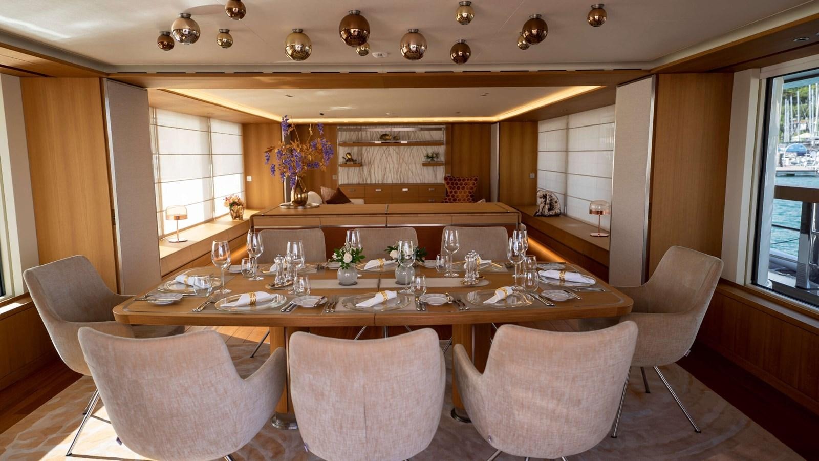a large dining table with chairs aboard AMIKA Yacht for Sale