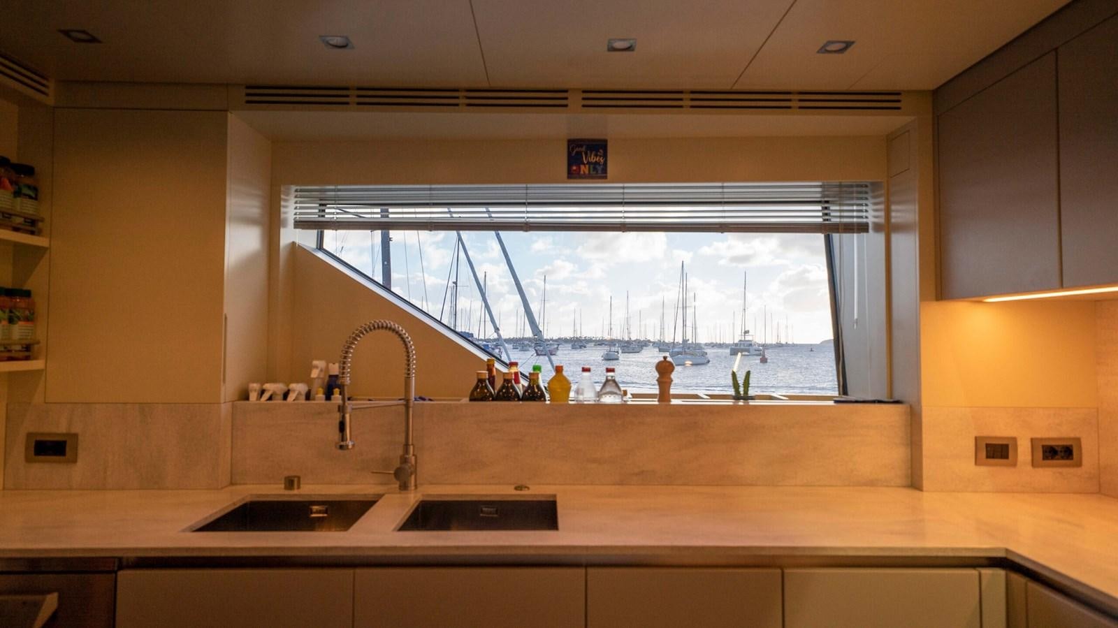 a kitchen with a large window aboard AMIKA Yacht for Sale