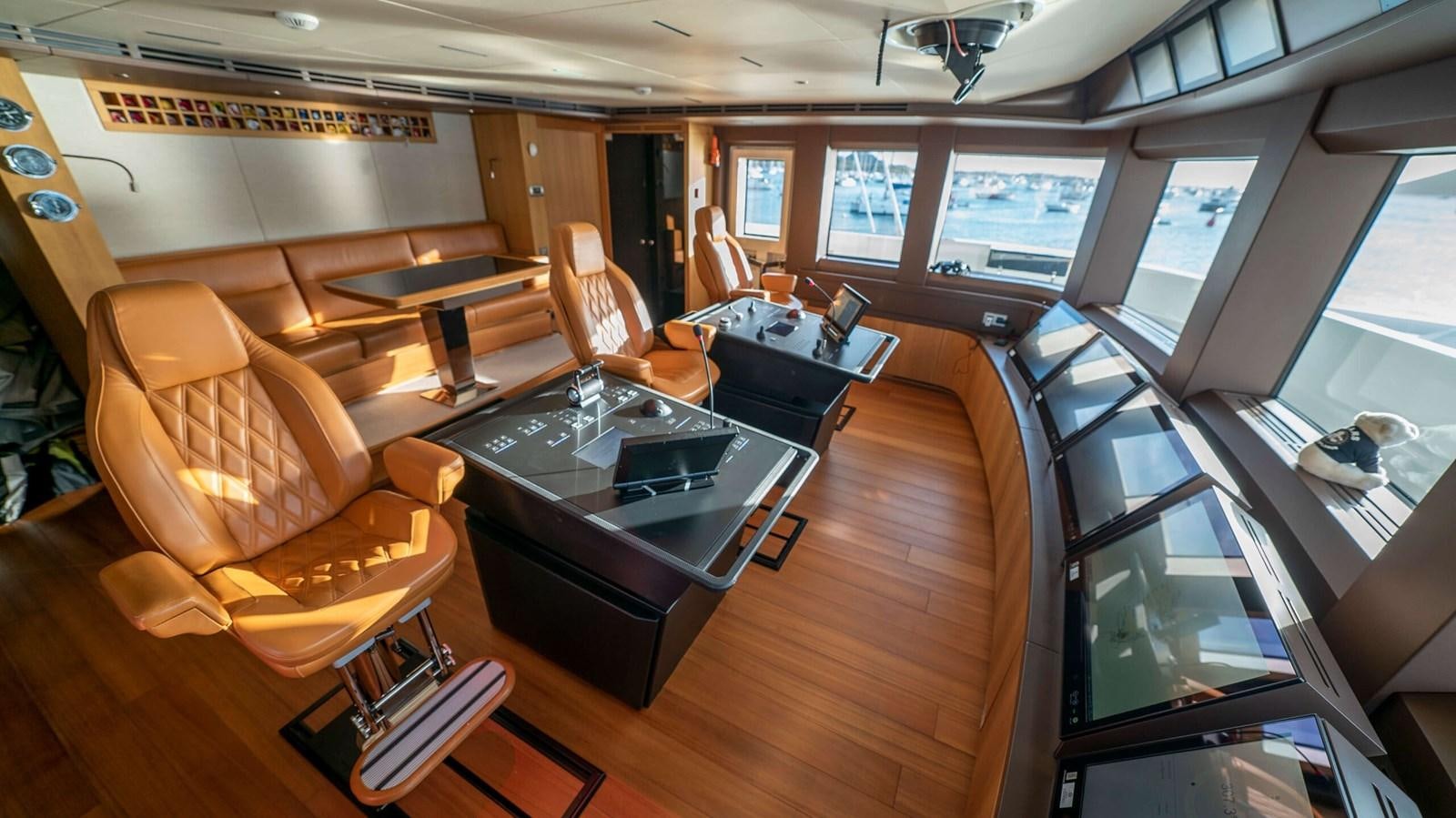 a room with a table chairs and a television aboard AMIKA Yacht for Sale