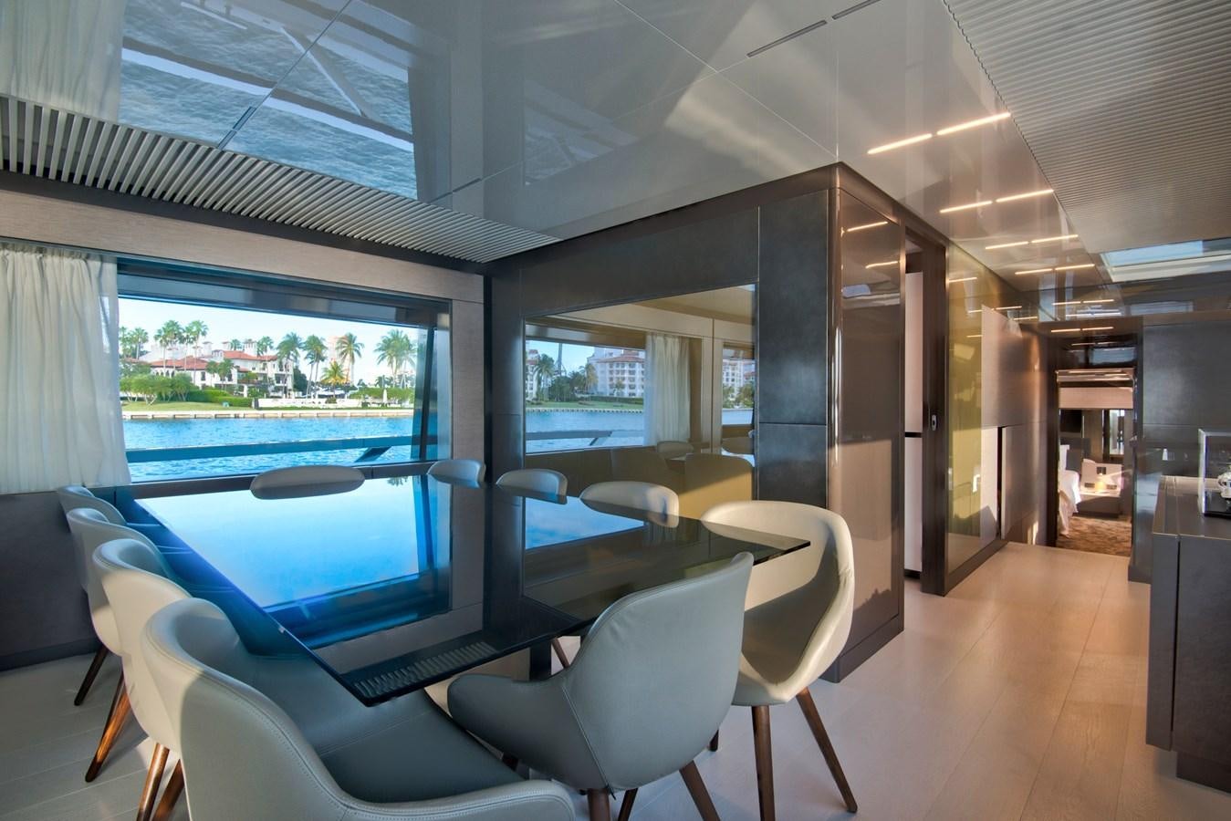 inside view of a room with a large window and a table with chairs aboard CIAO II Yacht for Sale