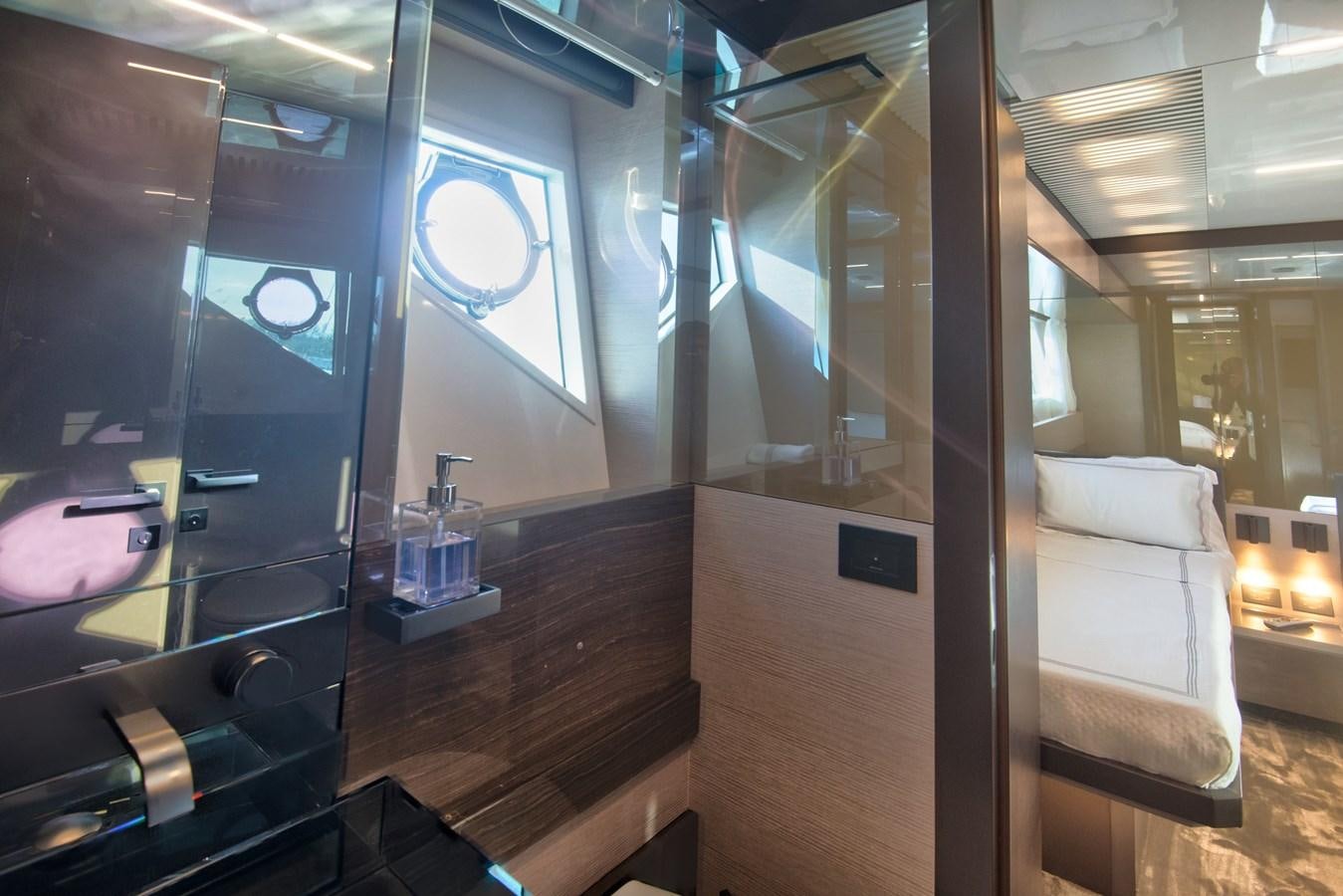 a room with a glass wall and a table with chairs and a window aboard CIAO II Yacht for Sale