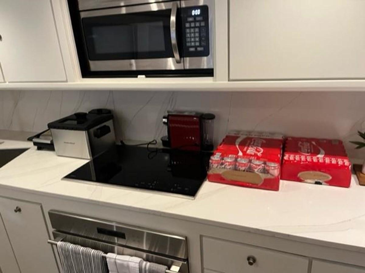 a microwave oven and some books on a counter aboard CENTURY STAR Yacht for Sale