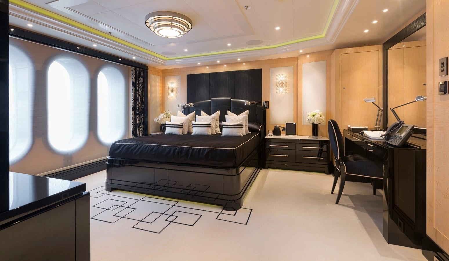 a bedroom with a bed and desk aboard PHOENIX 2 Yacht for Sale