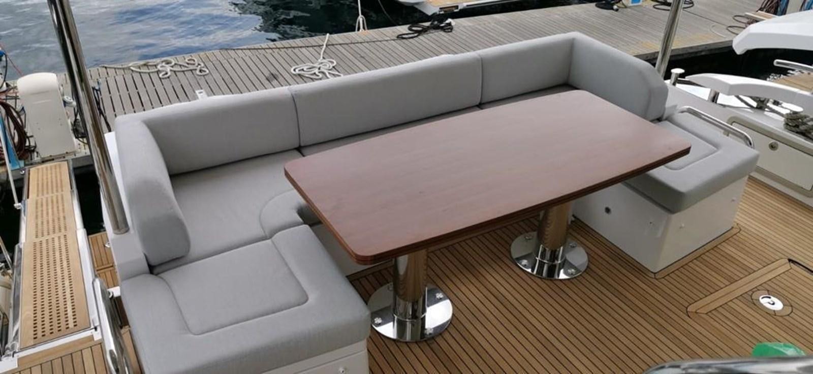 a white boat on a wooden deck aboard GOLDINIA Yacht for Sale