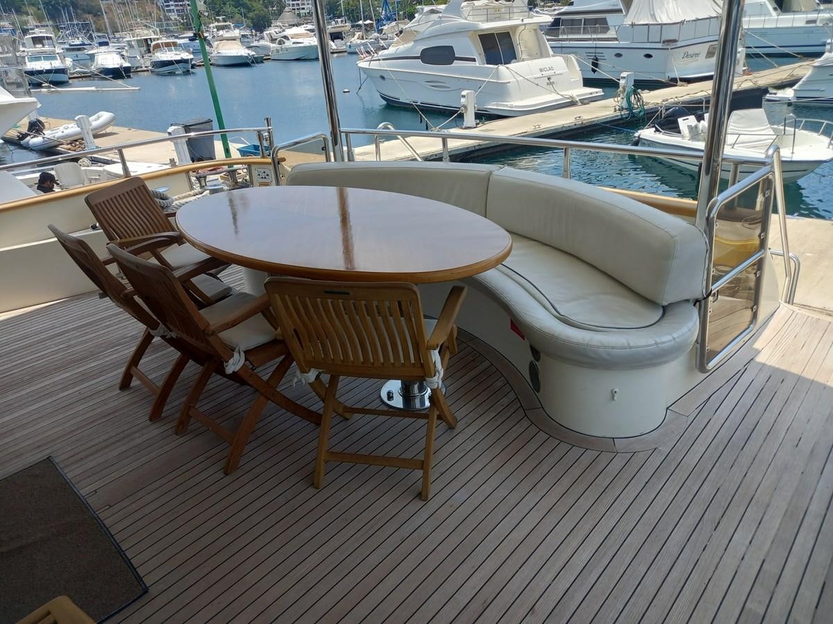 a table and chairs on a deck aboard TANGO - 2003 AZIMUT 85 ULTIMATE @ ACAPULCO Yacht for Sale