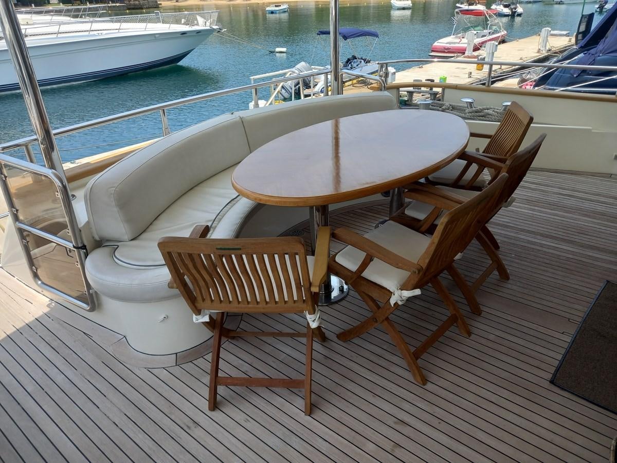 a table and chairs on a deck aboard TANGO - 2003 AZIMUT 85 ULTIMATE @ ACAPULCO Yacht for Sale