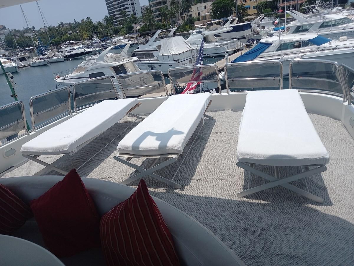 a group of lounge chairs on a deck with a view of a city aboard TANGO - 2003 AZIMUT 85 ULTIMATE @ ACAPULCO Yacht for Sale