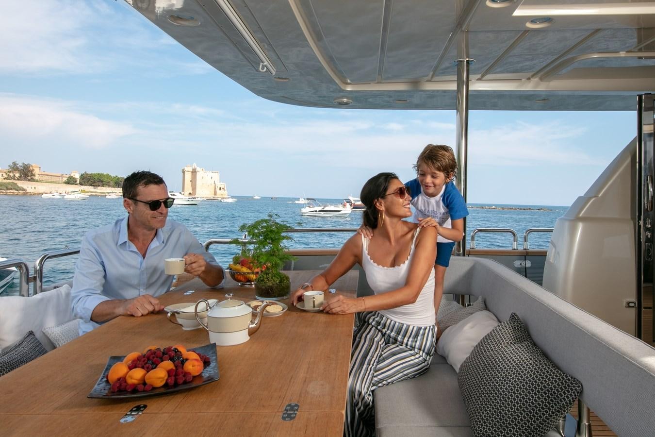 a family enjoying a meal on a boat aboard NEW CANADOS 888 EVO Yacht for Sale