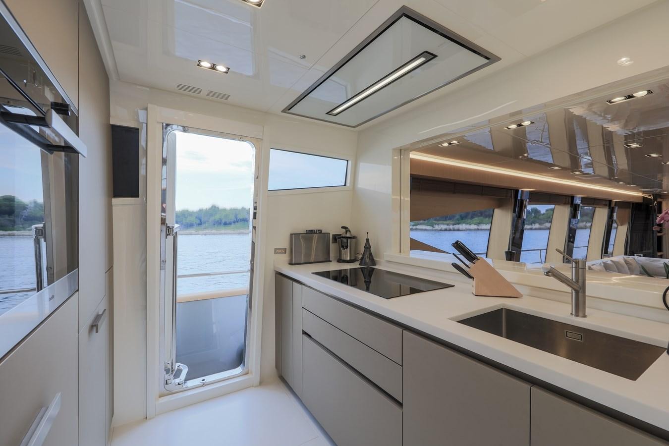 a kitchen with a large window aboard NEW CANADOS 888 EVO Yacht for Sale