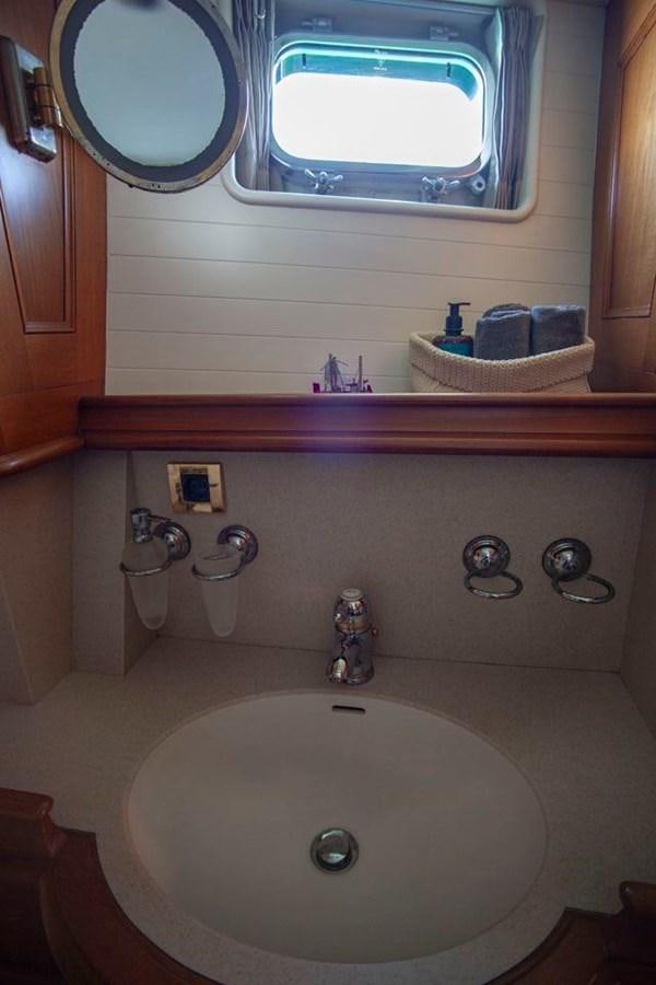 a bathroom with a round mirror aboard SWEET EMOTION Yacht for Sale