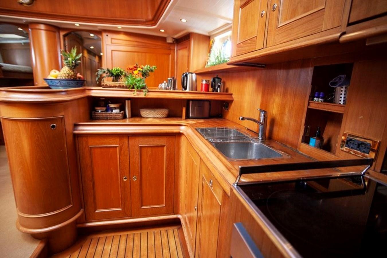 a kitchen with wooden cabinets aboard SWEET EMOTION Yacht for Sale