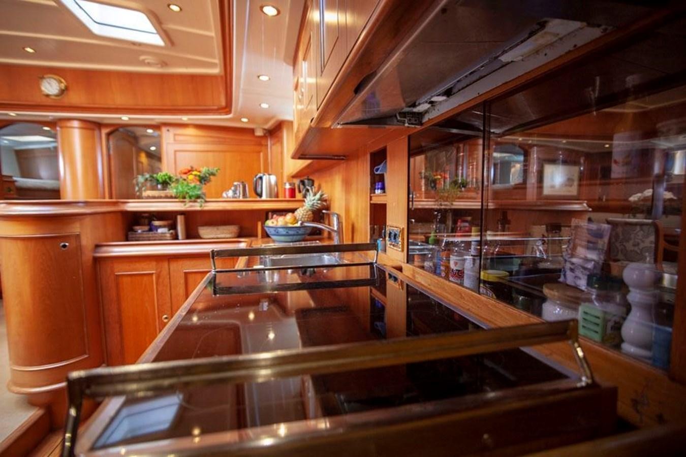 a kitchen with wooden cabinets aboard SWEET EMOTION Yacht for Sale