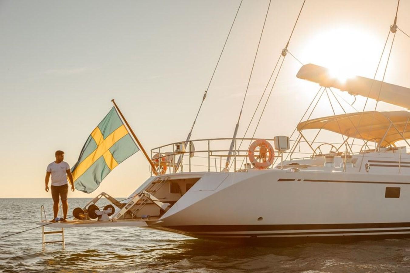 a person standing next to a boat aboard PAULINE AF SKANOR Yacht for Sale