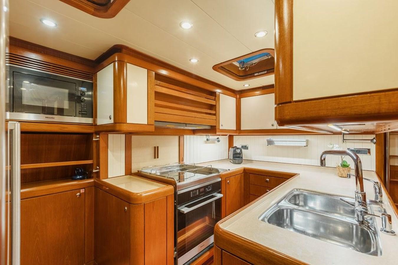 a kitchen with wooden cabinets aboard PAULINE AF SKANOR Yacht for Sale