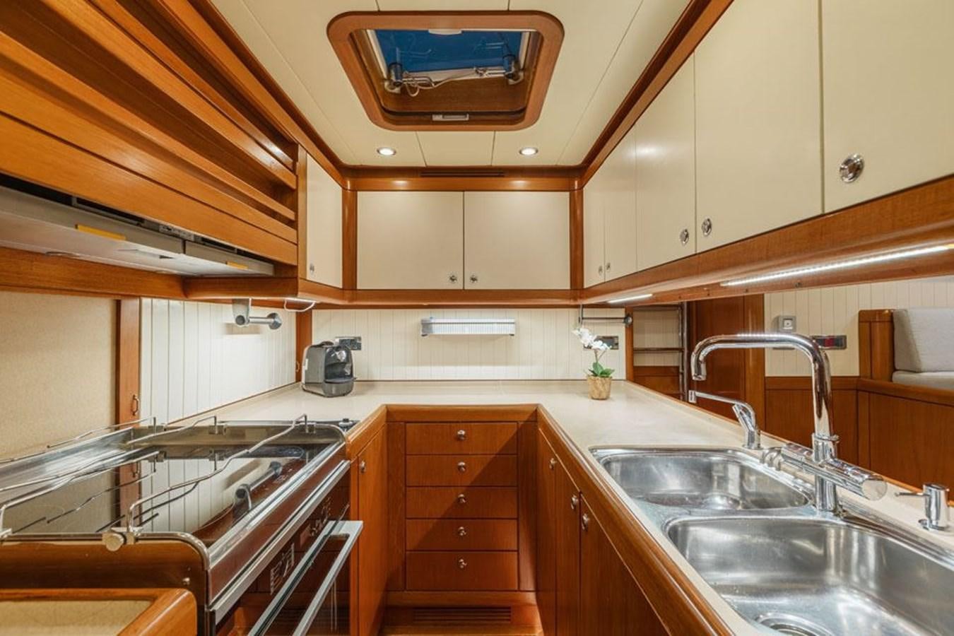 a kitchen with wooden cabinets aboard PAULINE AF SKANOR Yacht for Sale