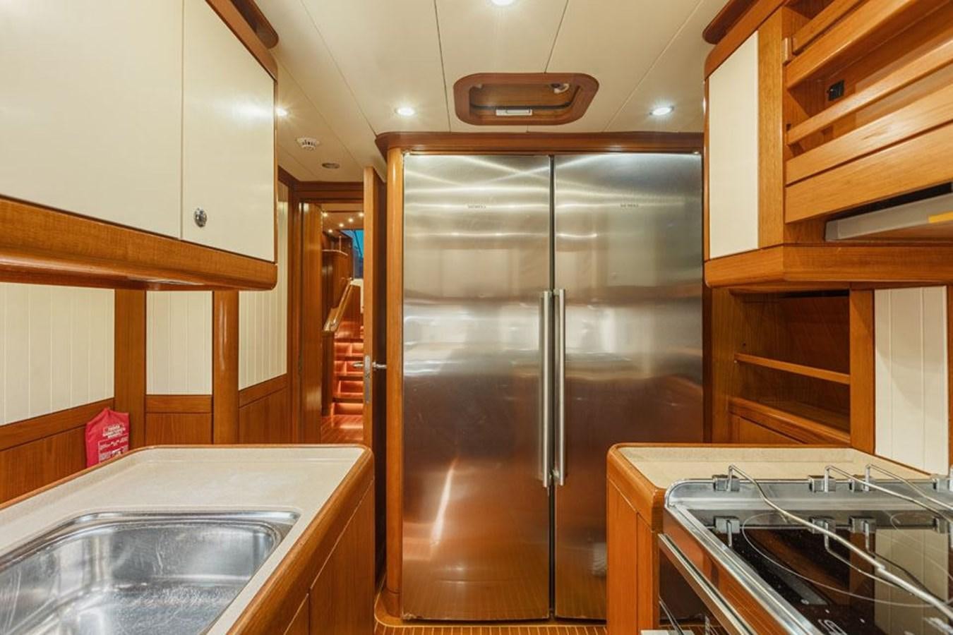 a kitchen with a stainless steel refrigerator aboard PAULINE AF SKANOR Yacht for Sale