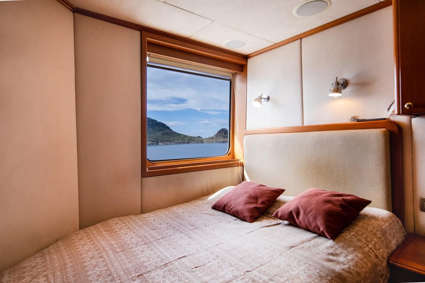 a bed with a large mirror above it aboard SEA FALCON II Yacht for Sale