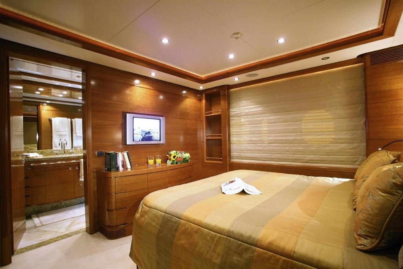 a bedroom with a bed and a tv aboard SEASCAPE V Yacht for Sale