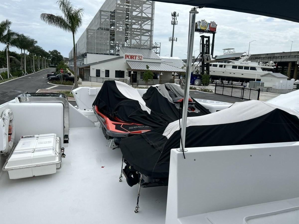 a white vehicle with a black hood parked on a street with buildings and trees and a car parked aboard MARGAUX Yacht for Sale