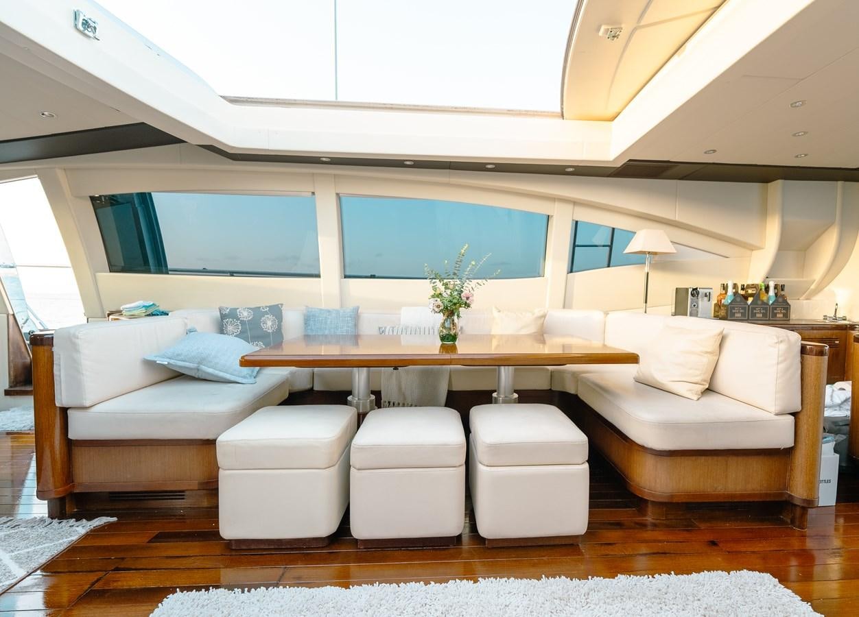 a living room with a table and couches aboard SCRATCH Yacht for Sale