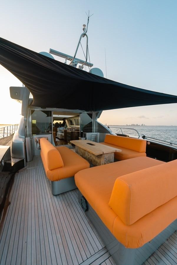a deck with a large boat and a chair on it aboard SCRATCH Yacht for Sale