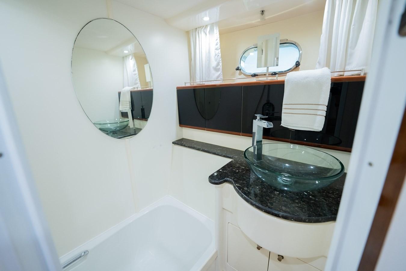 a bathroom with a round mirror aboard 70 Yacht for Sale