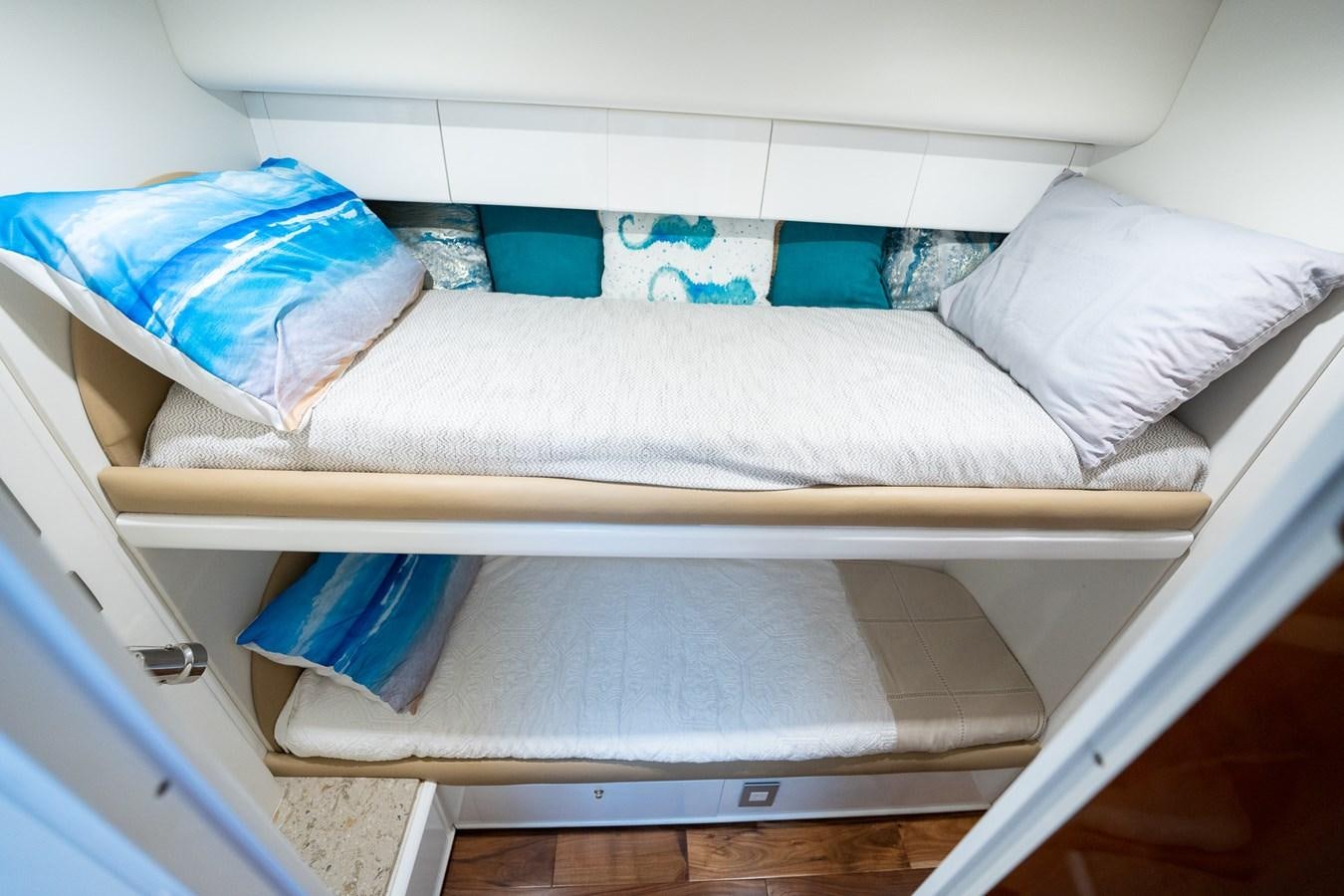 a white bed with blue and white pillows aboard 70 Yacht for Sale