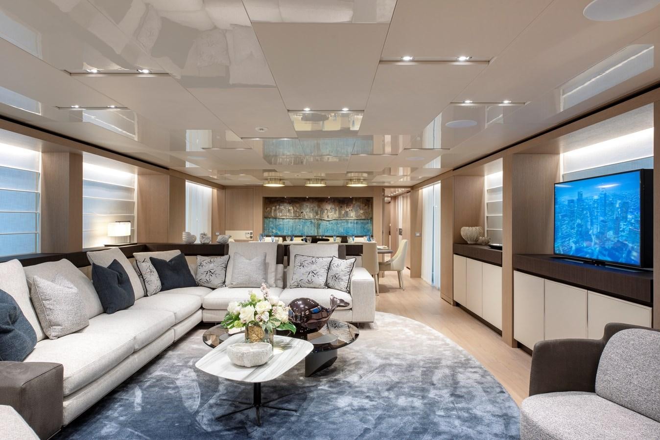 a living room with a large white couch and a large window aboard INSIEME Yacht for Sale