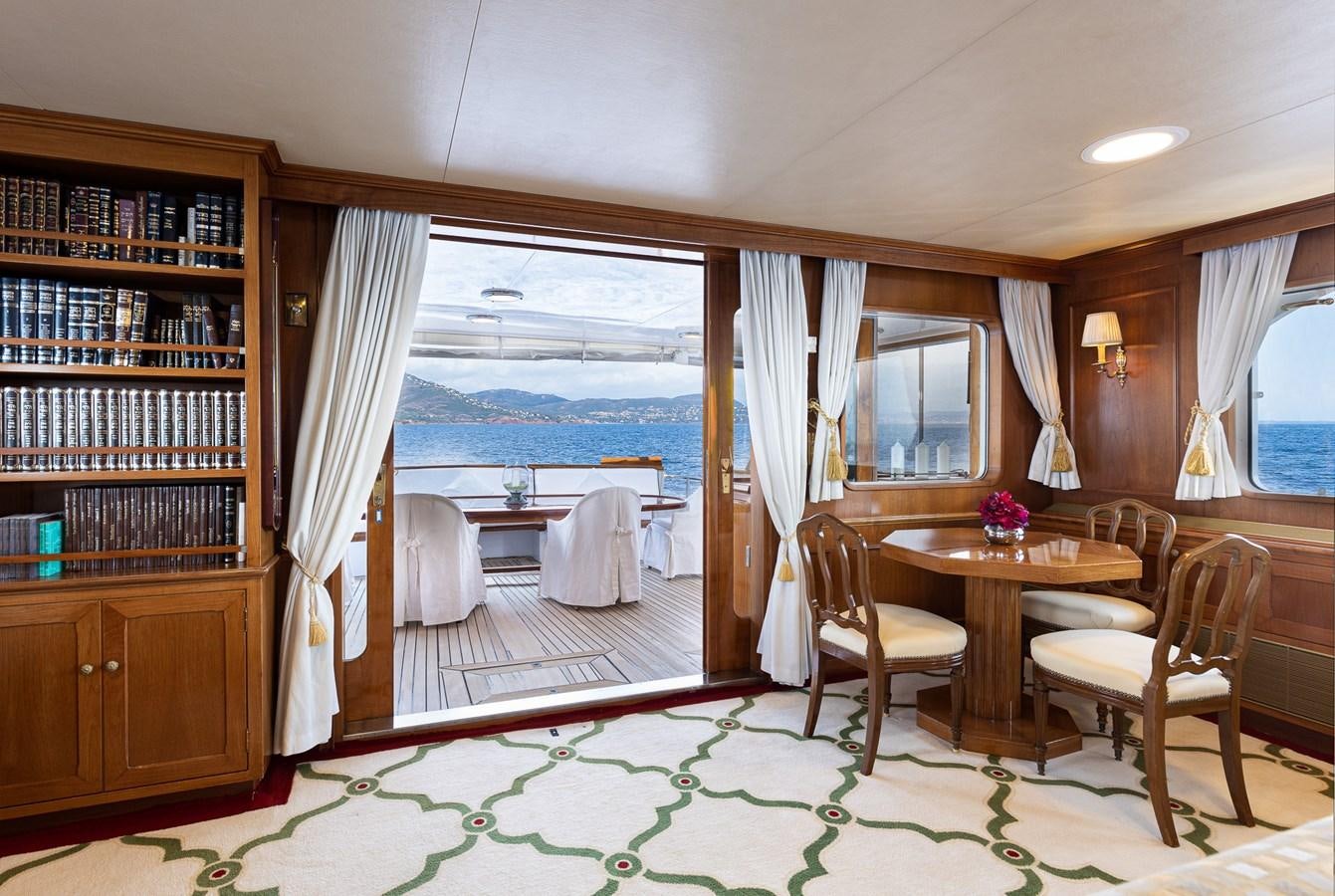 a room with a table chairs and a window aboard GIN TONIC Yacht for Sale