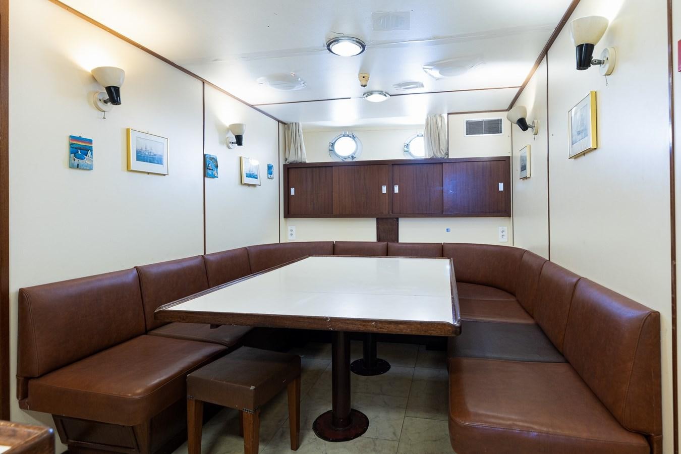a room with a table and couch aboard GIN TONIC Yacht for Sale