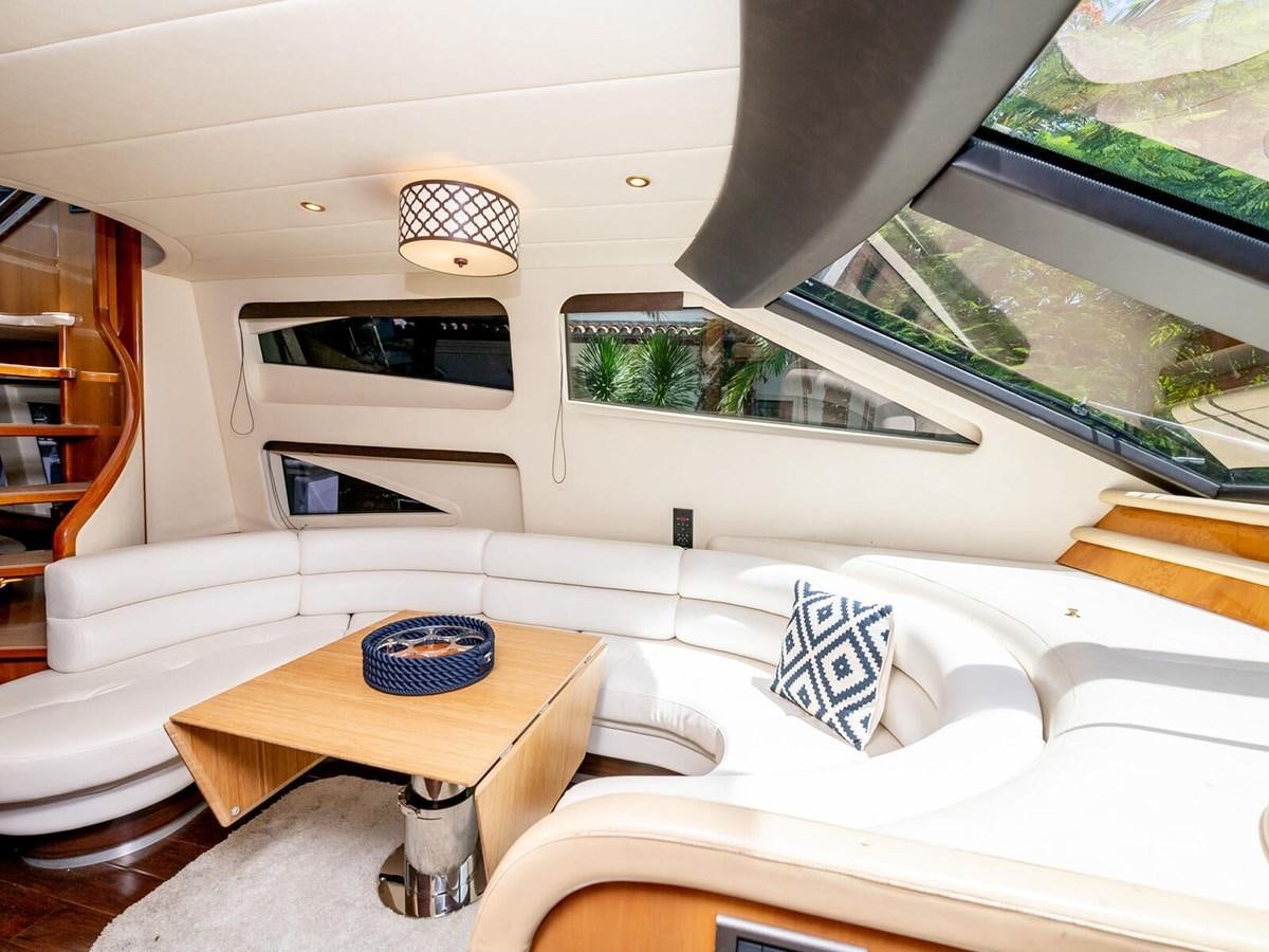 a white couch with a round table in a room with a window aboard NUEVA OLA Yacht for Sale