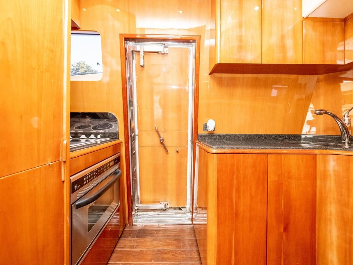 a kitchen with wooden cabinets aboard NUEVA OLA Yacht for Sale