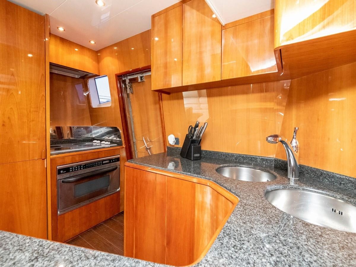 a kitchen with wooden cabinets aboard NUEVA OLA Yacht for Sale