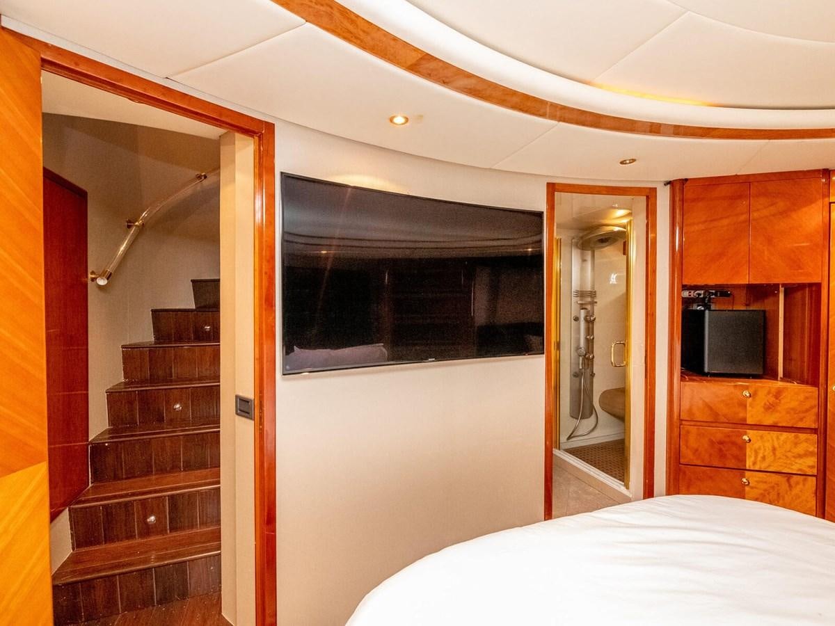 a bedroom with a bed and a television aboard NUEVA OLA Yacht for Sale